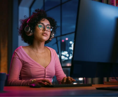 A woman with glasses working on a computer