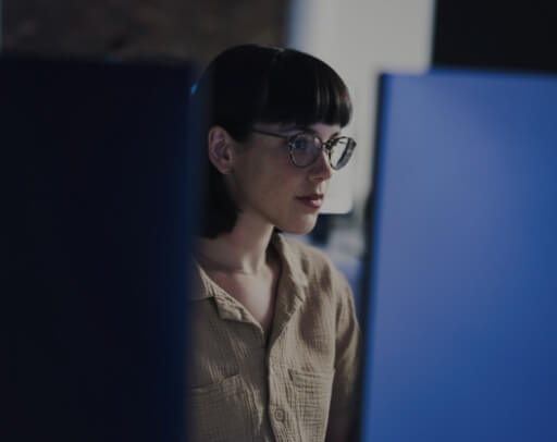 A woman with glasses working on a computer