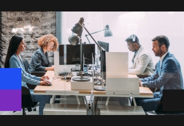 four people working on a computer